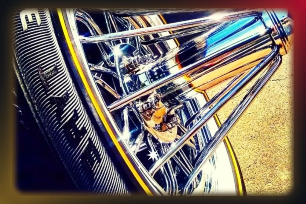 Chrome swanga wire wheel poking out on a gold-stripe Vogue tire